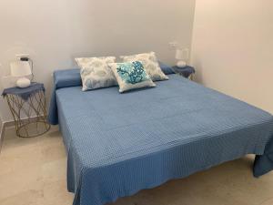 a blue bed with two pillows on top of it at Smeralda APARTMENT in Cannigione