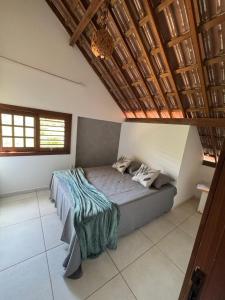 a bed in a bedroom with a wooden ceiling at Chalés serra linda in Bananeiras