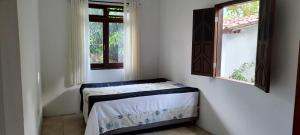 パウメイラスにあるCasa Amorのベッド2台と窓2つが備わる客室です。