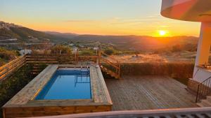 ḤurfeishHar-Adir B&B的甲板上的游泳池,背景是日落