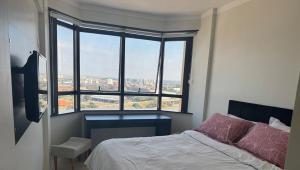 a bedroom with a bed and a large window at Flat mobiliado em Campinas - 201 in Campinas