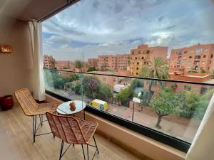 a large window with a view of a city at Gueliz Terracotta Stay - 2 BR & Cozy Balcony in Marrakech