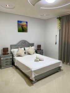ein Schlafzimmer mit einem großen Bett mit weißer Bettwäsche in der Unterkunft Duplex - Pool and Beach in Dar Hamida + 24 Fotos
