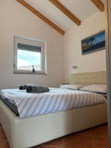 a bed in a room with a window at Apartment Maja in Dobrinj