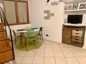 a kitchen with a table and chairs and a tv at Old Porlezza Apartment in Porlezza