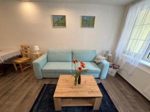 a living room with a blue couch and a table at U Staré plynárny in Hřensko