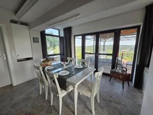 a dining room with a table and chairs and windows at Kuća za odmor MIRTA in Grkavešćak