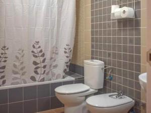 Un baño con inodoro y cortina de ducha. en Apartment in Peñaflor with Charming Patio, en Peñaflor