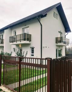 a white house with a black fence at Casa Elena in Râşnov