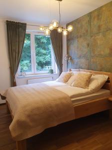 a bedroom with a large bed in front of a window at Apartament Łynova z parkingiem podziemnym in Olsztyn