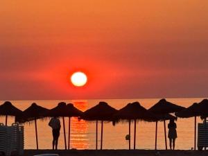 two people standing on the beach watching the sunset at Boho Beach Flats in Valencia