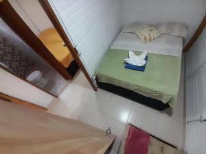 a small room with a small bed and a mirror at Cabaña Barbacoas in Santa Ana