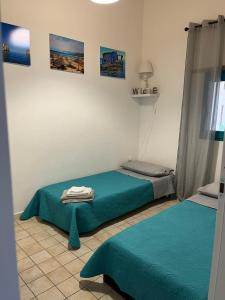 Un dormitorio con dos camas con sábanas azules. en Casa Mia, en Villamassargia