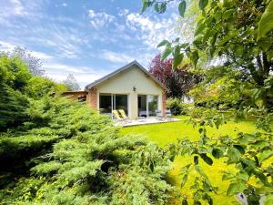 a small house in a yard with a lawn sidx sidx sidx at Nature luxuriante, jeux en famille, workation et Sauna pour 1 à 4 personnes in Labosse