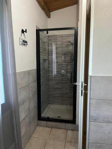 una ducha con puerta de cristal en un baño en Casa Mia, en Villamassargia