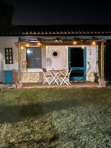 Una casa con un porche con una silla y luces. en Casa Mia, en Villamassargia