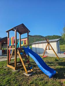 a playground with a slide in the grass at Deluxe House Aqua Una in Otoka