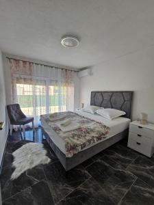 a bedroom with a bed and a chair and a window at Deluxe House Aqua Una in Otoka