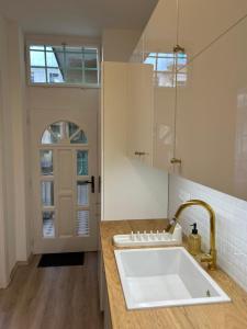a kitchen with a white sink and a door at Museum Apartment by City Park Budapest in Budapest