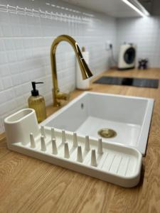 a white sink in a kitchen with a faucet at Museum Apartment by City Park Budapest in Budapest