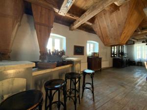 a bar with stools in a room with wooden ceilings at Stary młyn nad Tywą in Gryfino