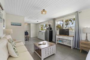 Una sala de estar con un sofá y un televisor. en WLR5 - Studio near Palm Beach - White Lotus Retreat, en Palm-Eagle Beach