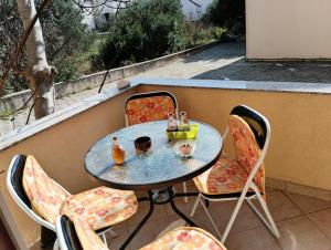 a table and chairs with drinks on a balcony at Apartman Jadranka in Zaboric