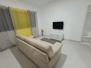 a living room with a couch and a tv at Elly Apartamentos2 in Mindelo