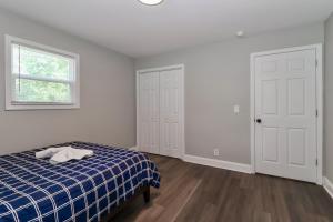 Un dormitorio con una cama de cuadros azules y una ventana en Tillery Trail Retreat Mount Gilead, en Mount Gilead