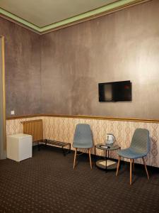 a waiting room with two chairs and a tv on a wall at Nostalgia Old City Bucharest in Bucharest