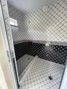 a bathroom with a glass shower door with a tile floor at Guest House in Racha Almagi in Ambrolauri +13 photos