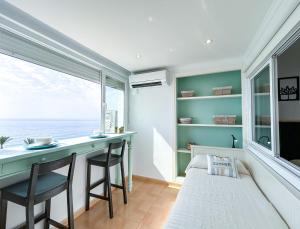 a room with a bed and a desk and a window at Modern appartment with sea views in Sabinillas in San Luis de Sabinillas