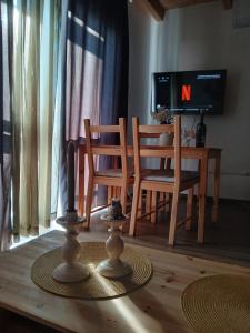 a living room with a table and chairs and a television at Vulcanus Apartment in Badacsonytomaj