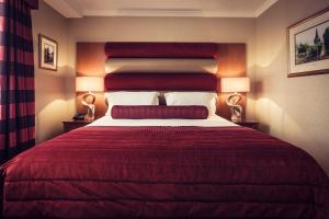 Postel nebo postele na pokoji v ubytování Carlton George Hotel