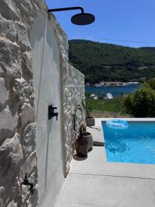 a stone wall with a swimming pool next to a house at Pool 4 Leisure Dubrovnik in Dubrovnik