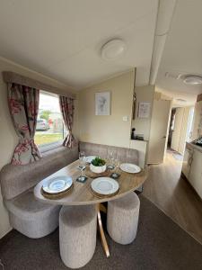 a living room with a table and a couch at Andreas Fir Trees Retreat at 7 Lakes Country Park in Crowle
