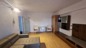 ein Wohnzimmer mit einer Couch und einem Tisch mit Stühlen in der Unterkunft Garsoniera spațioasă in Constanţa