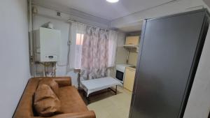 ein kleines Wohnzimmer mit einem Sofa und einer Küche in der Unterkunft Garsoniera spațioasă in Constanţa