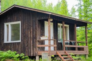 a tiny house in the woods with a porch at Raasepori camping in Raseborg