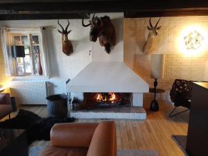 a living room with a fireplace withanimal heads on the wall at Hotel Strandvejen in Fanø