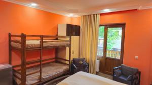 ディリジャンにあるVAN Guesthouseのオレンジ色の壁の部屋に二段ベッドが2つある寝室