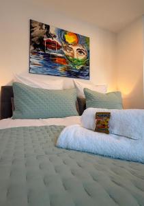 a bedroom with a bed with a painting on the wall at Gemütliches Apartment nähe HBF-City--Lift in Hannover