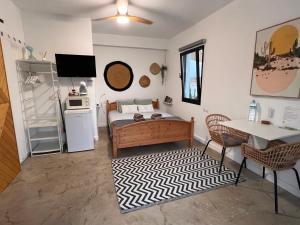 a bedroom with a bed and a table and a refrigerator at Casa Nusa in La Santa