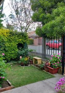 a garden with pots of flowers and a fence at Casa Roble Añejo Bed & Breakfast in Santa Cruz