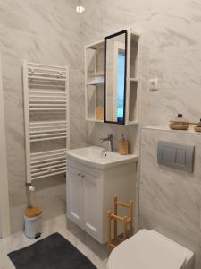 a white bathroom with a sink and a mirror at Apartman Lola Palić II in Palić +18 photos