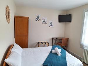 a bedroom with a bed and a tv on the wall at La cocotte in Soullans