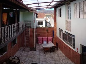 an outdoor patio with a table and chairs on a balcony at República Minas Novas in Ouro Preto