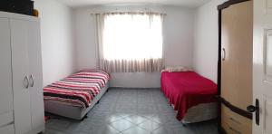 a bedroom with two beds and a window at República Minas Novas in Ouro Preto