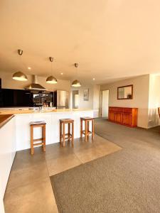 a kitchen with two bar stools and a counter at West Meadows Escape, Lake & Slopes Minutes Away in Wanaka