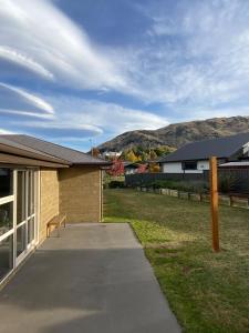 a bench sitting on a sidewalk next to a house at West Meadows Escape, Lake & Slopes Minutes Away in Wanaka +4 photos